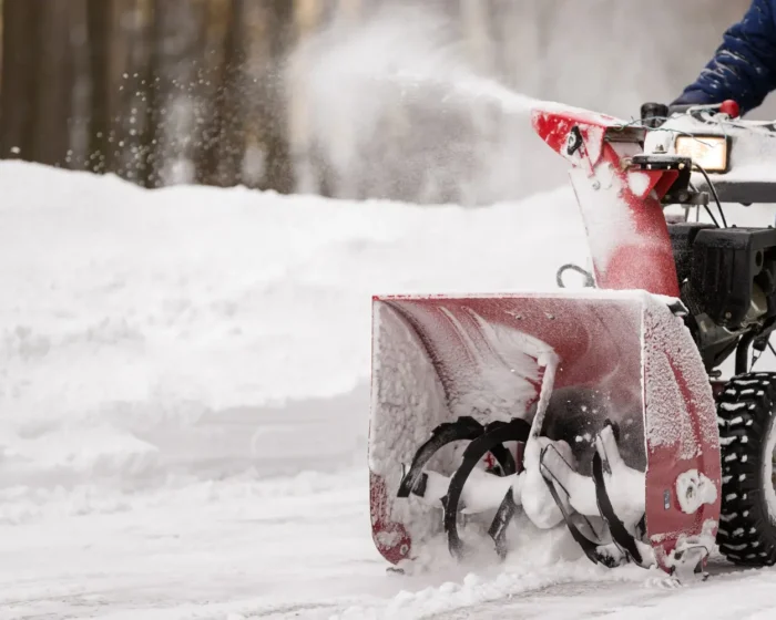 Snow plow clearing commercial parking lot